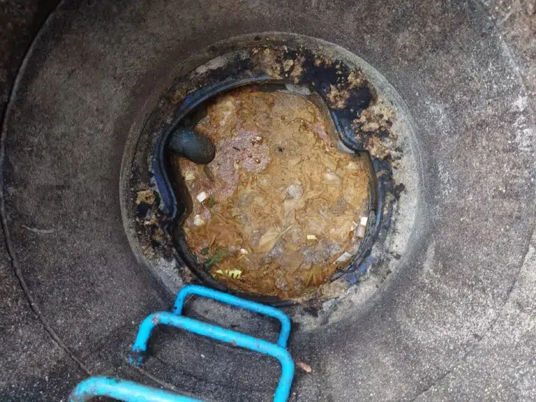 Photo d'un bac à graisse du secteur de la restauration plein qu'il faut vider et nettoyer.