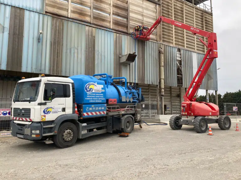 Photo d'un véhicule ADR sur un chantier industriel à coté d'une nacelle.